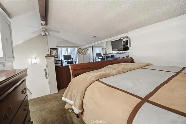 a bedroom with a bed a flat screen tv and dresser