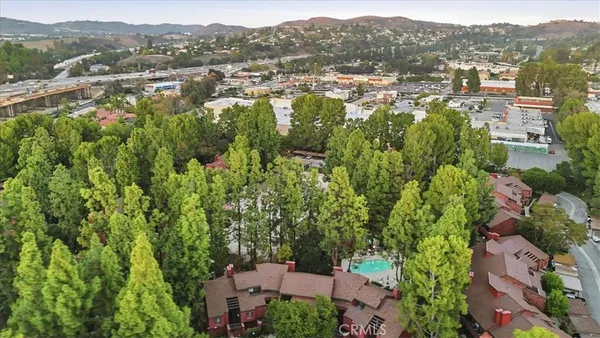 an aerial view of residential houses with outdoor space and trees