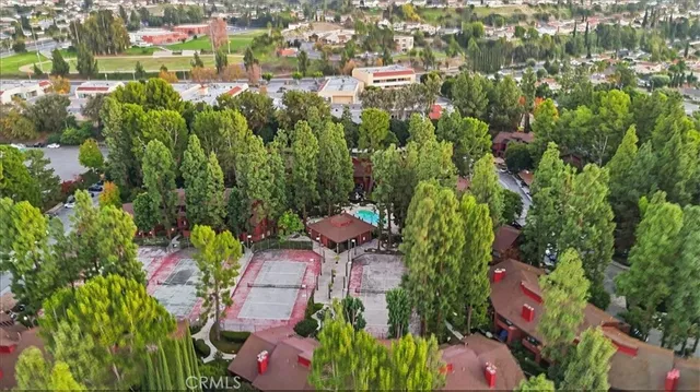 an aerial view of residential house with outdoor space and trees all around