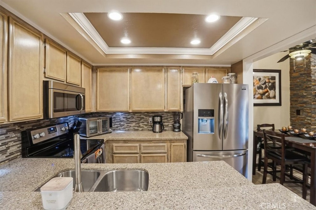 300 South Prospectors Road, Unit 29 Diamond Bar, CA 91765 - Photo 10 of 37 a kitchen with stainless steel appliances kitchen island granite countertop a refrigerator a stove a sink a dining table and chairs with wooden floor