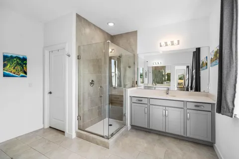 a spacious bathroom with a shower sink and mirror
