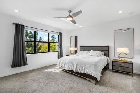 a bedroom with a bed and a large window