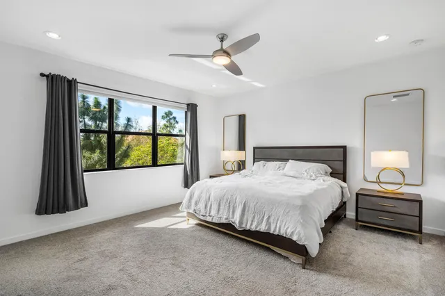 a bedroom with a bed and a large window