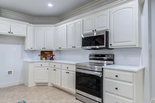 a kitchen with white cabinets stainless steel appliances and sink