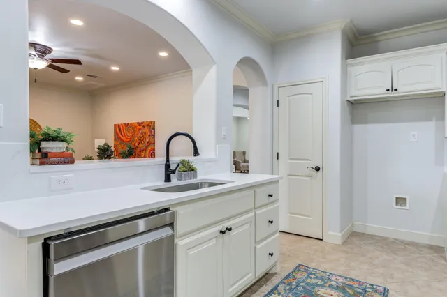 a kitchen with white cabinets and a refrigerator