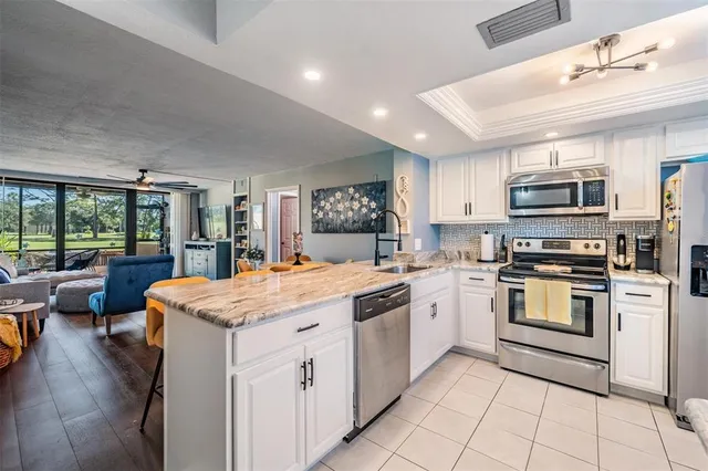 a kitchen with stainless steel appliances granite countertop a sink and dishwasher a stove top oven with wooden floor