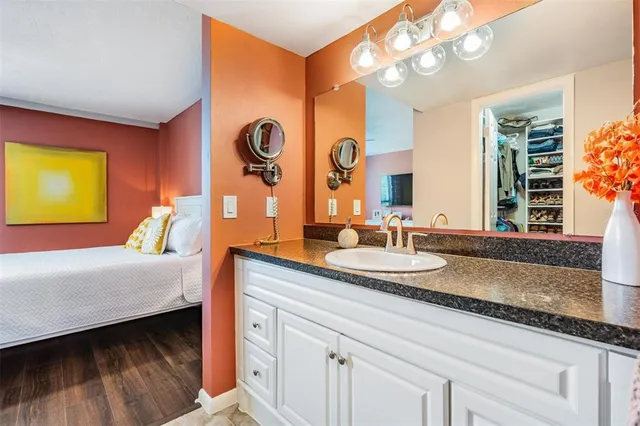 a en suite bathroom with a granite countertop double vanity and a mirror