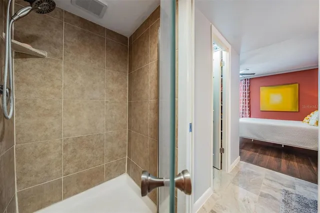 a en suite bathroom with a granite countertop sink a mirror and shower