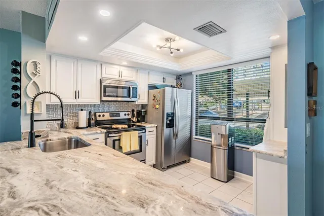 a kitchen with stainless steel appliances granite countertop a refrigerator and a stove top oven