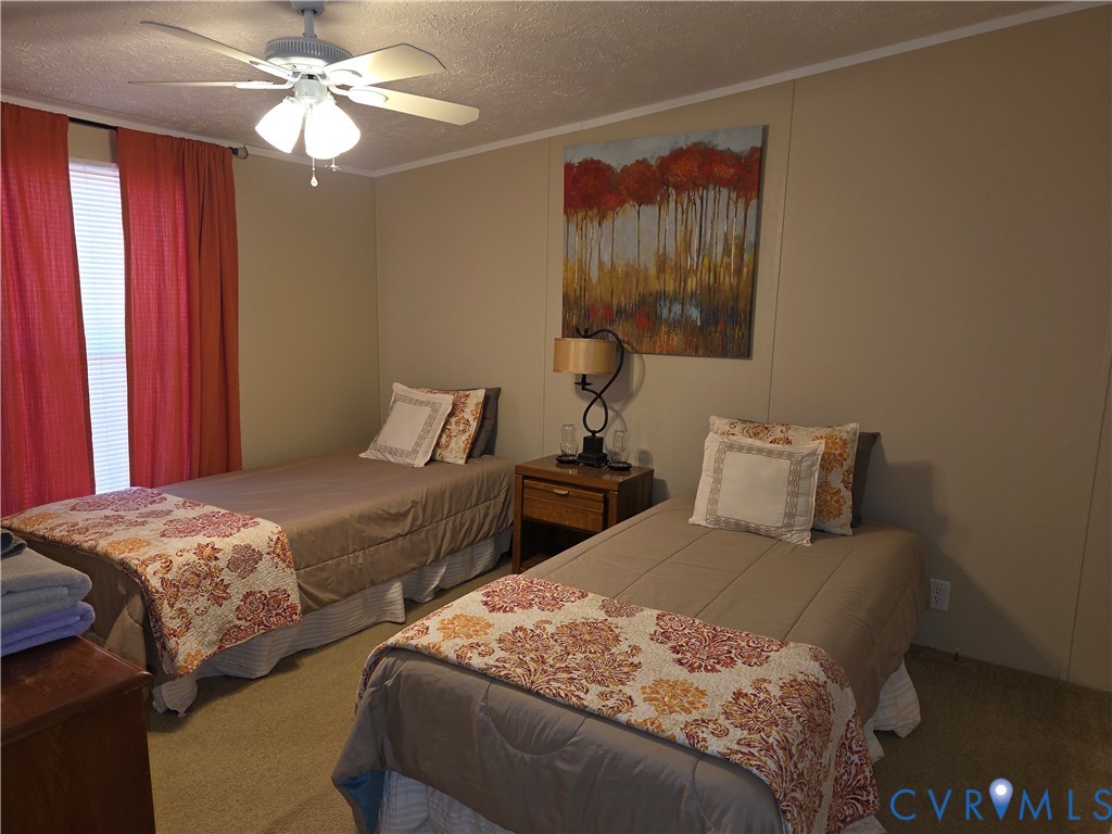 1585 Ullainee Road Caret, VA 22436 - Photo 7 of 10 a bedroom with two beds and a chandelier