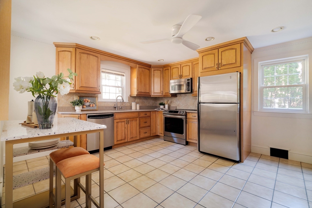 143 South Street Brookline, MA 02467 - Photo 13 of 32 a kitchen with a refrigerator a sink dishwasher with a dining table and chairs