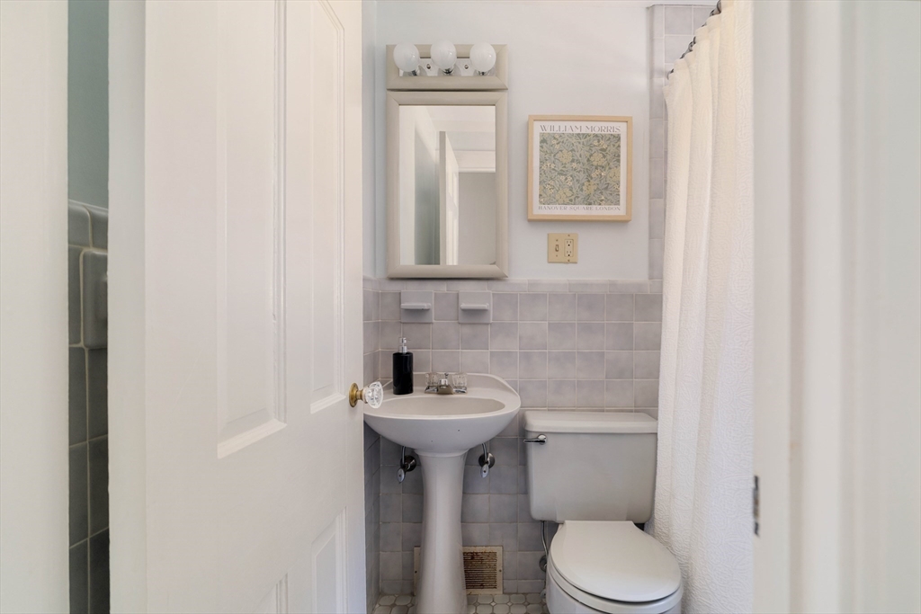 143 South Street Brookline, MA 02467 - Photo 17 of 32 a bathroom with a toilet sink and mirror