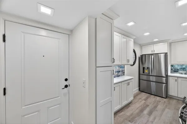 a kitchen with refrigerator cabinets and wooden floor