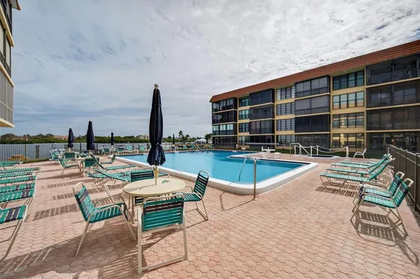 a view of swimming pool with chairs in front of house