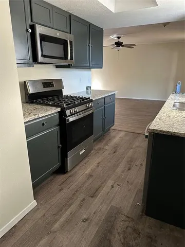 a kitchen with stainless steel appliances kitchen island granite countertop a stove a sink and a microwave