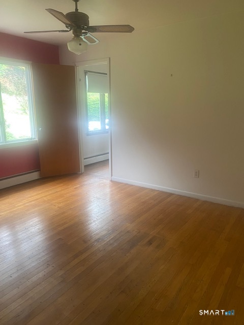 107 Tower Road Brookfield, CT 06804 - Photo 12 of 19 an empty room with wooden floor and windows