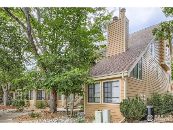 a view of a house with a yard and potted plants