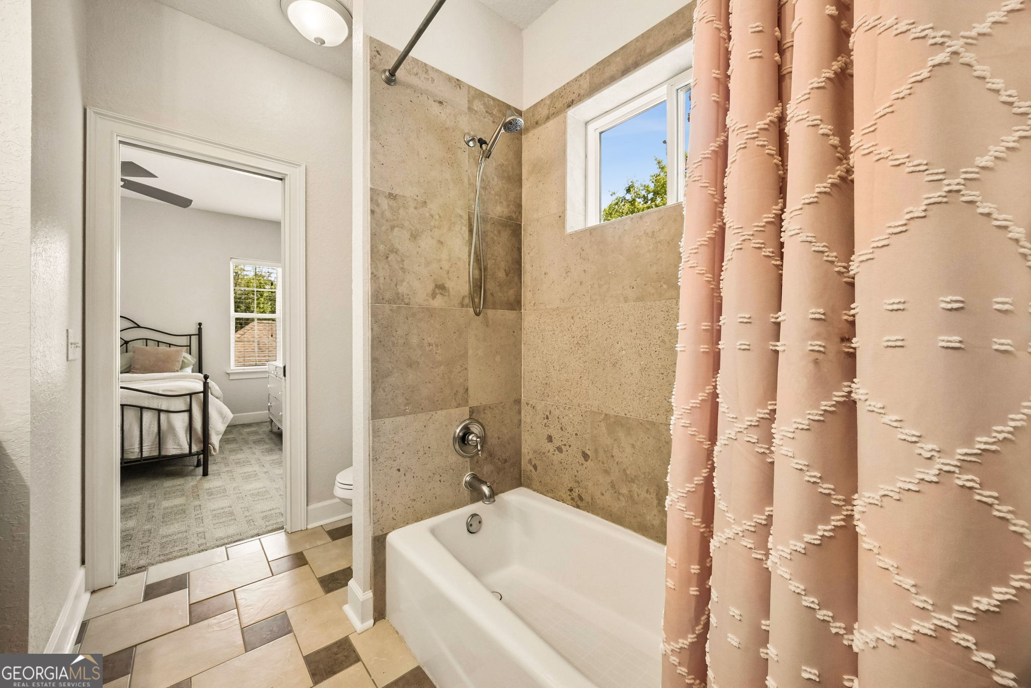 706 Hopewell Point Road White Oak, GA 31568 - Photo 43 of 84 Full bathroom with tiled tub surround, shower, and natural light from the window.