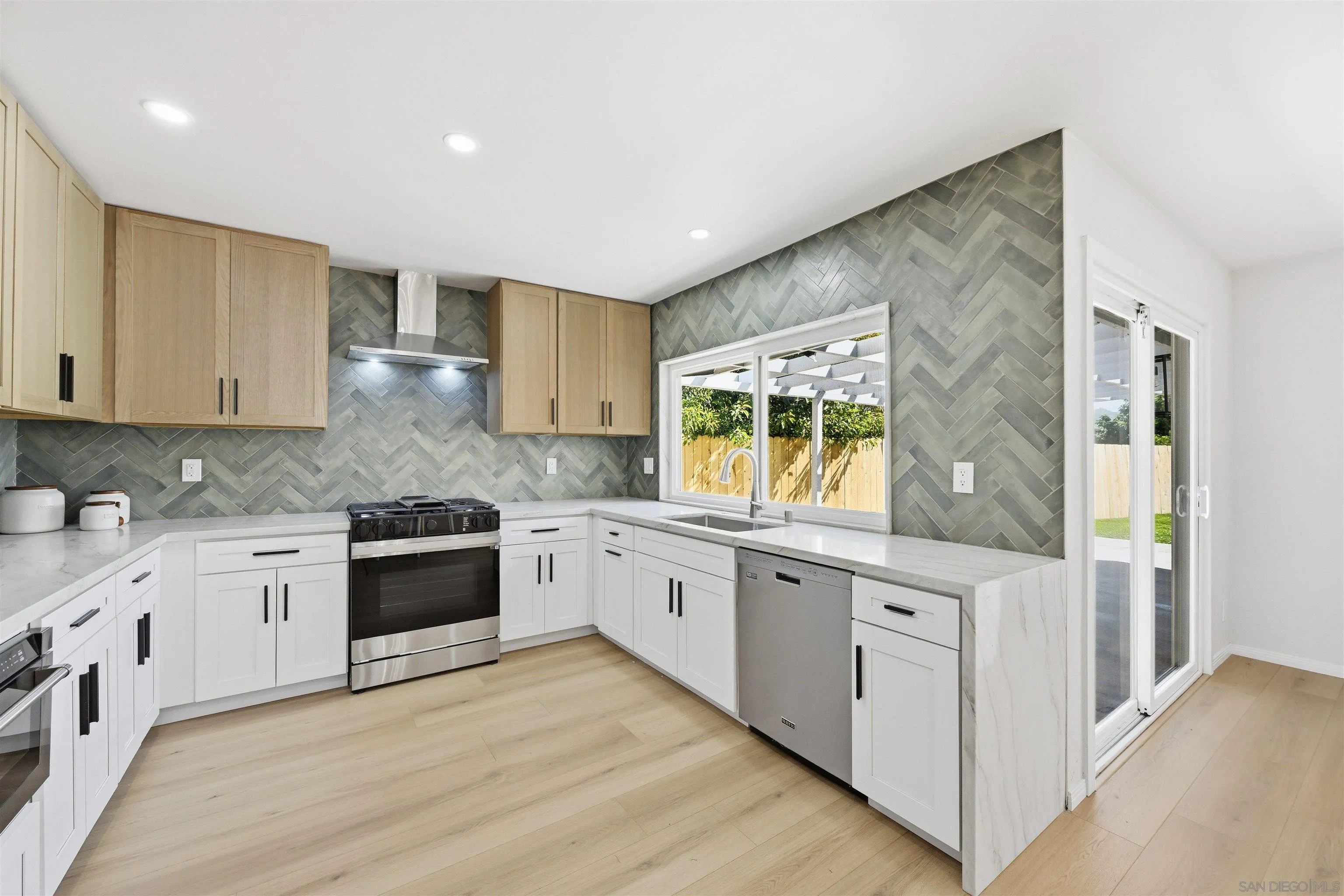 a large kitchen with stainless steel appliances granite countertop a stove and a sink