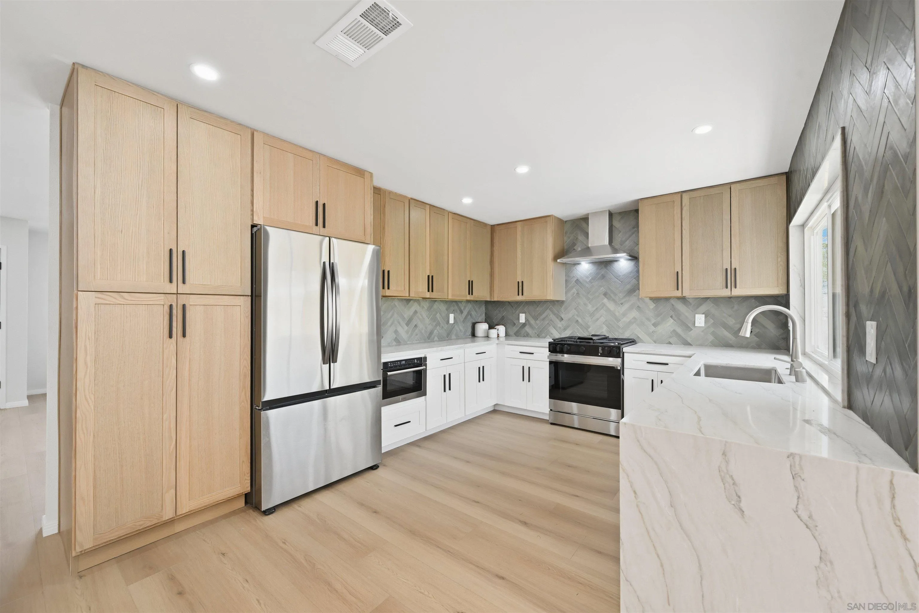 12437 Ridgeton Drive Lakeside, CA 92040 - Photo 12 of 32 a kitchen with granite countertop white cabinets and white stainless steel appliances