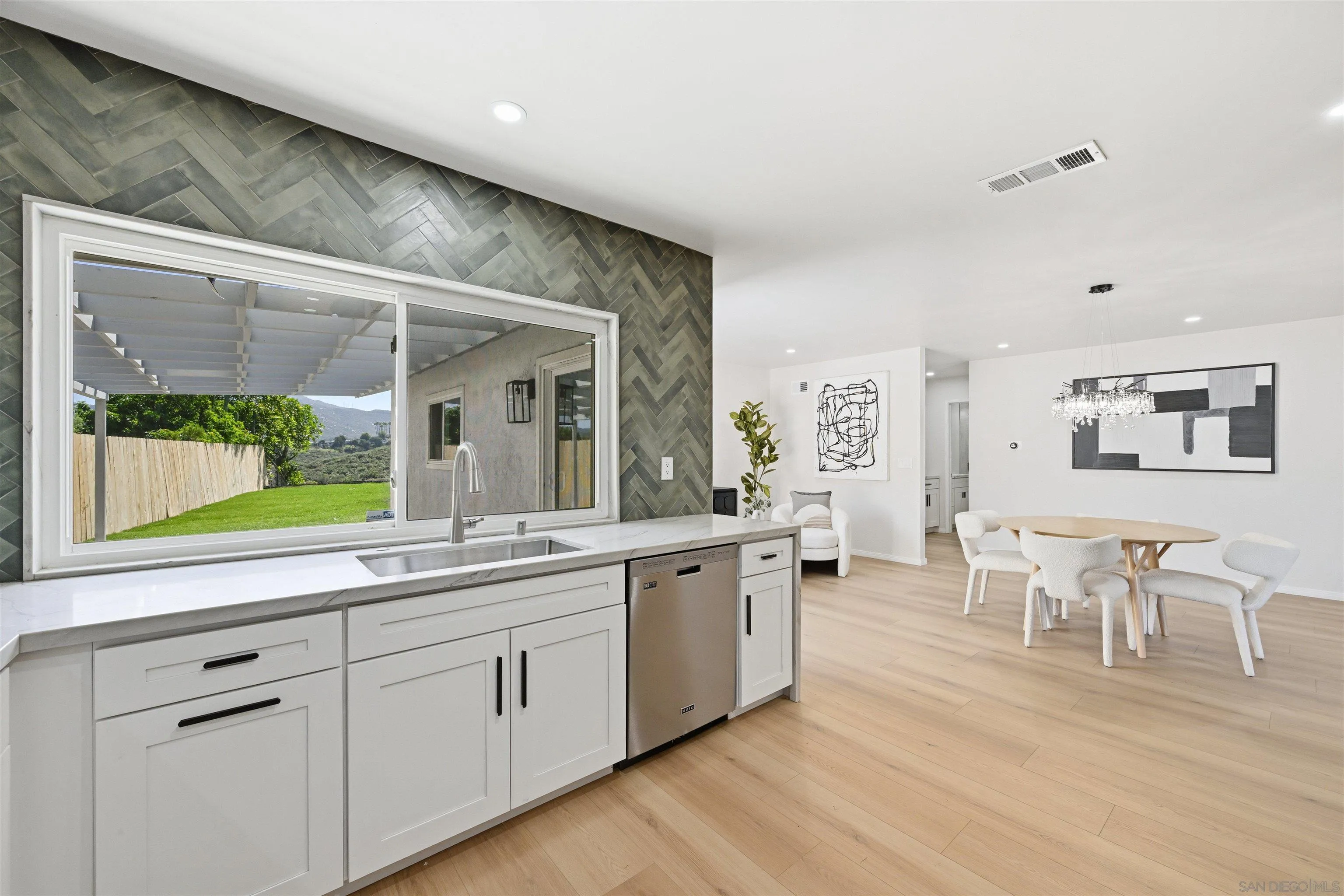 12437 Ridgeton Drive Lakeside, CA 92040 - Photo 13 of 32 a large living room with stainless steel appliances granite countertop a couch and a large window with wooden floor