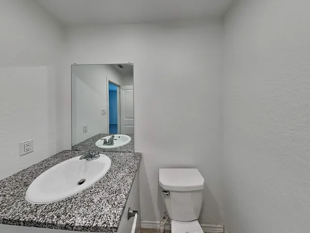 a bathroom with a sink toilet and mirror