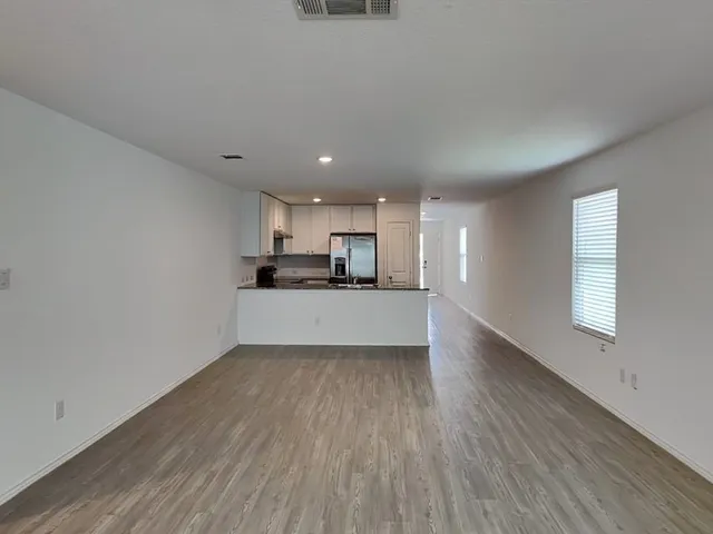 a view of kitchen with wooden floor and electronic appliances