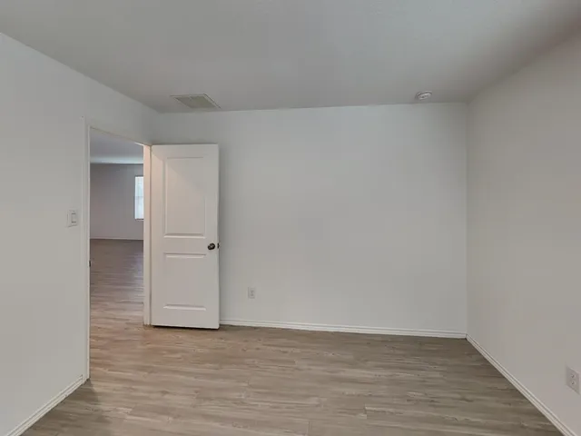 a view of an empty room and wooden floor