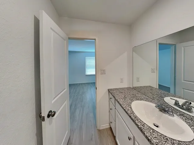 a bathroom with a granite countertop sink a mirror and vanity