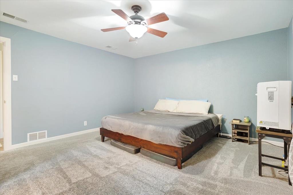 1418 Blanton Place Sherman, TX 75092 - Photo 22 of 33 a spacious bedroom with a bed and a chandelier
