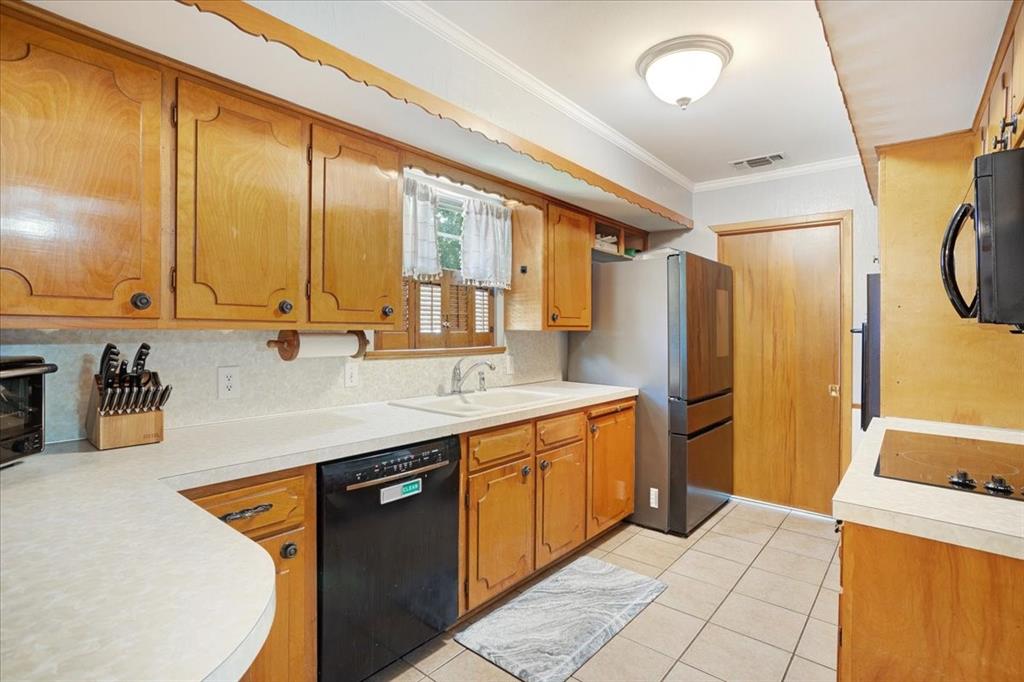 1418 Blanton Place Sherman, TX 75092 - Photo 10 of 33 a kitchen with a sink a refrigerator and cabinets