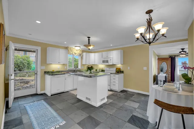 a kitchen with stainless steel appliances granite countertop a sink a stove and cabinets