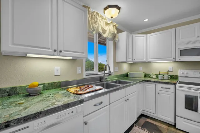 a kitchen with stainless steel appliances granite countertop a sink and cabinets