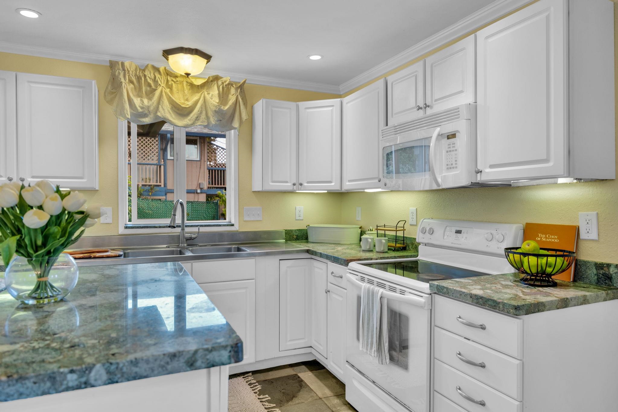 1123 Kehau Place Makawao, HI 96768 - Photo 29 of 50 a kitchen with stainless steel appliances granite countertop a sink and a white cabinets