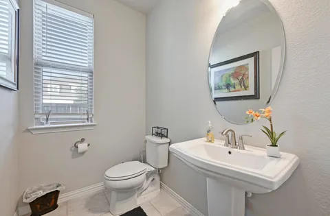 a bathroom with a toilet a sink and a mirror