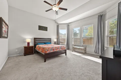 a spacious bedroom with a large bed and a chandelier