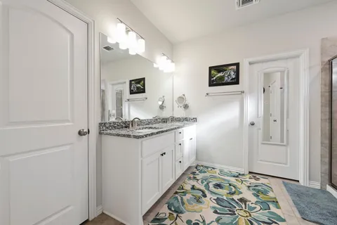 a bathroom with a granite countertop sink and a mirror