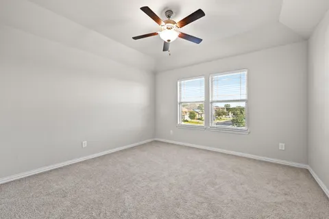 an empty room with a window and a ceiling fan