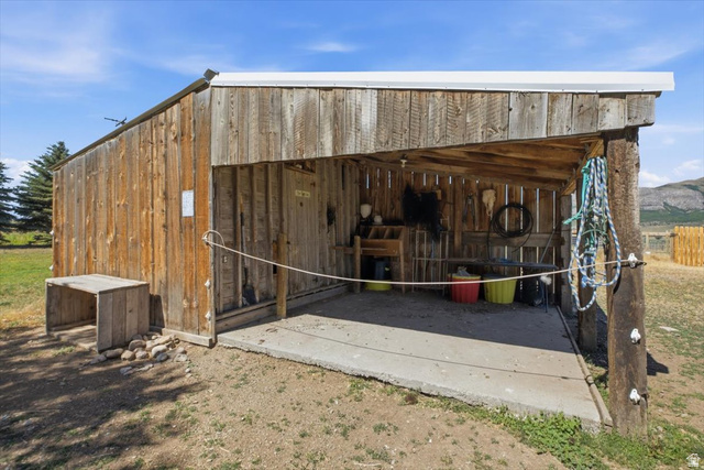 1634 West Arimo Road Arimo, ID 83214 - Photo 54 of 89 Rustic wooden outbuilding with a corrugated metal roof and a concrete floor