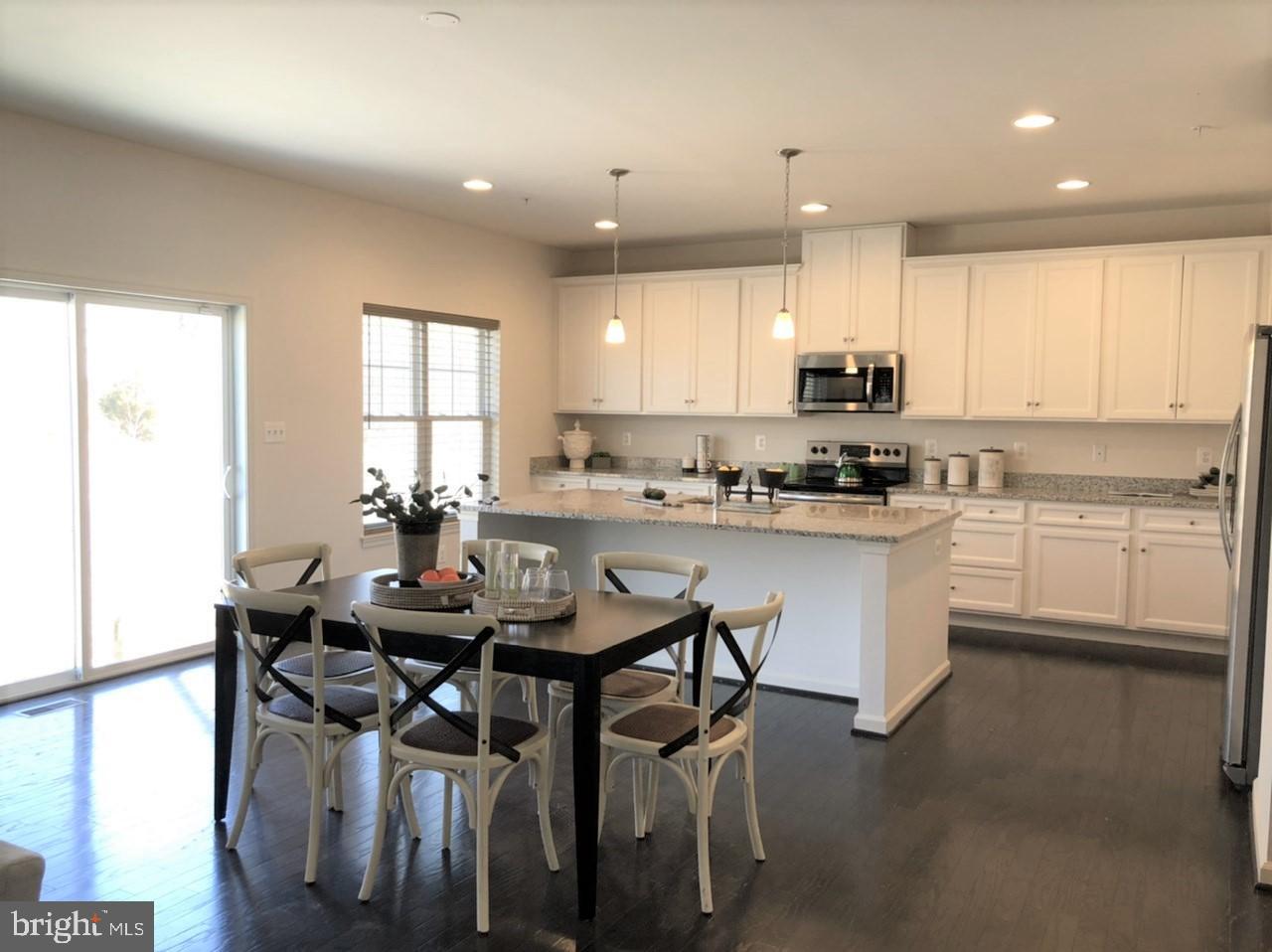 201 Featherstone Road Pasadena, MD 21122 - Photo 5 of 19 a kitchen with a table chairs sink and cabinets