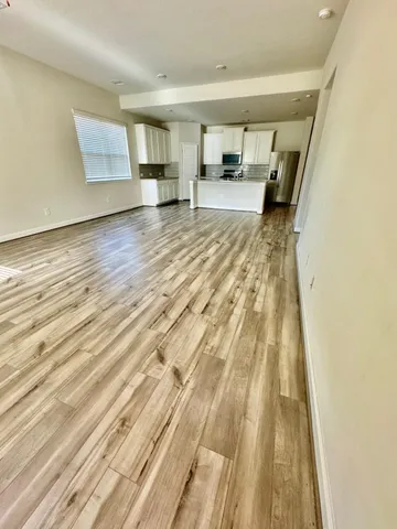 a big room with wooden floor and a window