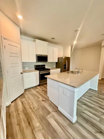 a kitchen with stainless steel appliances a refrigerator and a stove top oven