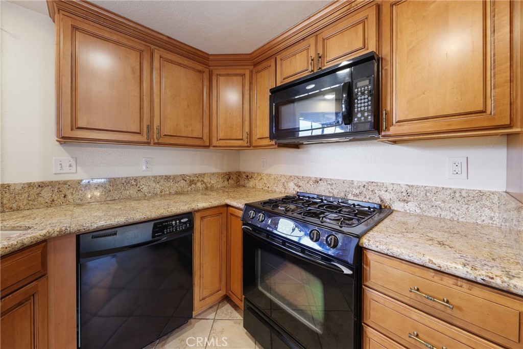 14 Abrigo Rancho Santa Margarita, CA 92688 - Photo 14 of 40 a kitchen with granite countertop a stove a microwave a sink and cabinets