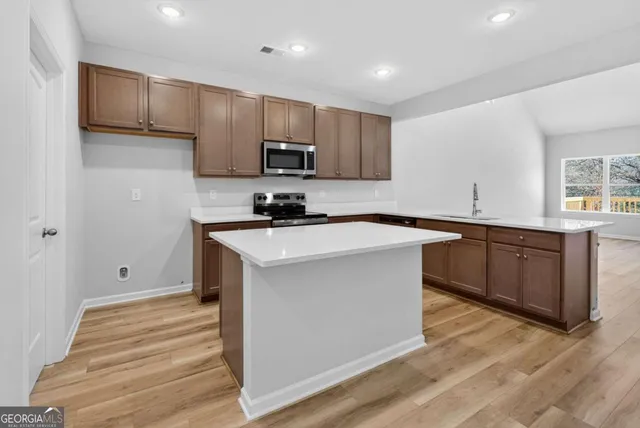 a kitchen with stainless steel appliances a sink stove and cabinets