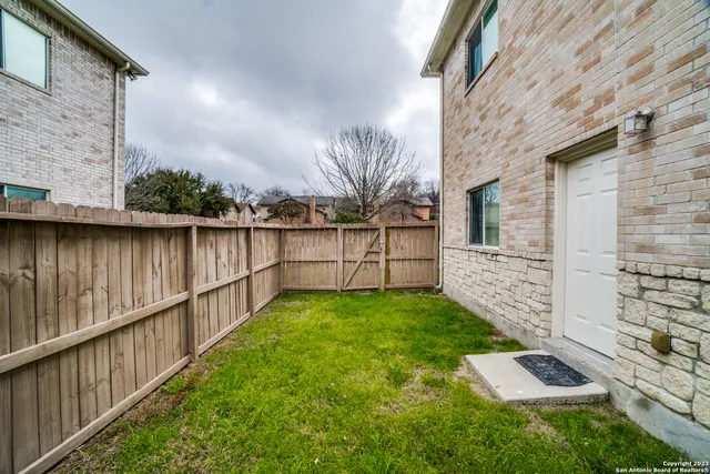a view of a backyard with wooden fence