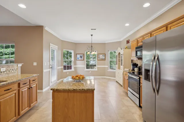 a kitchen with stainless steel appliances granite countertop a refrigerator and a sink