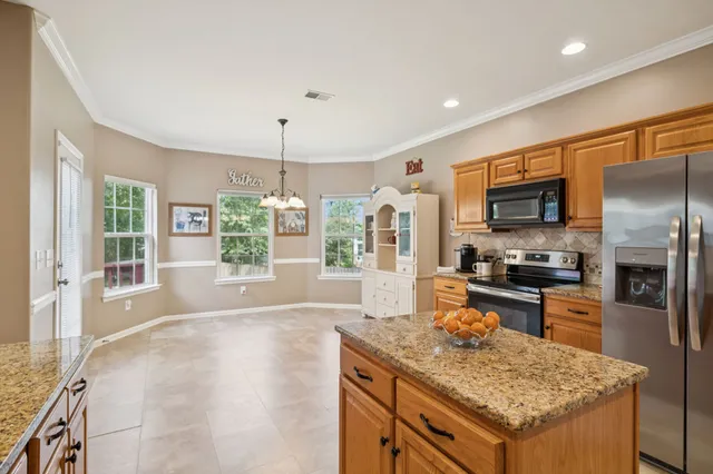 a kitchen with stainless steel appliances granite countertop a sink stove and refrigerator