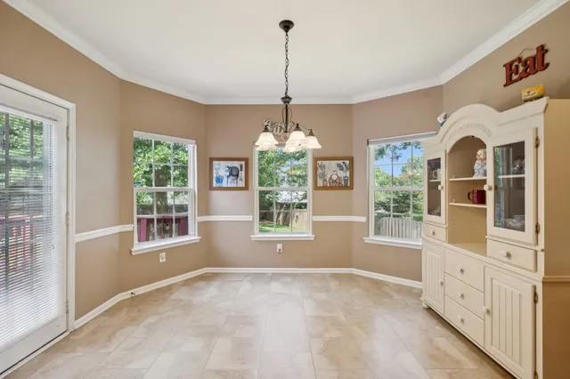 a view of an empty room with window and cabinet area
