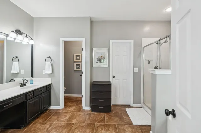 a bathroom with a double vanity sink mirror and shower