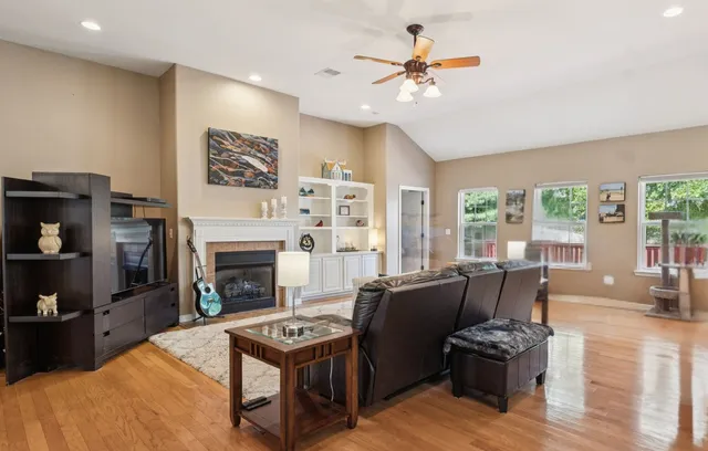 a living room with furniture a fireplace and a large window